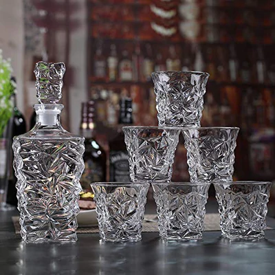 Crystal whiskey decanter with six matching whiskey glasses on a bar counter