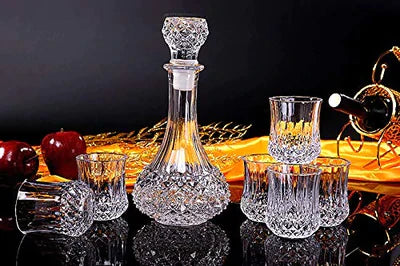 Crystal whiskey decanter set with six matching glasses on a reflective surface, elegant barware.
