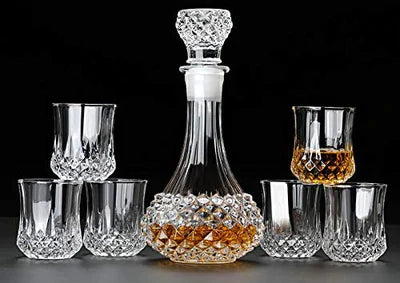 Crystal whiskey decanter set with six matching cut glass tumblers on a dark background.