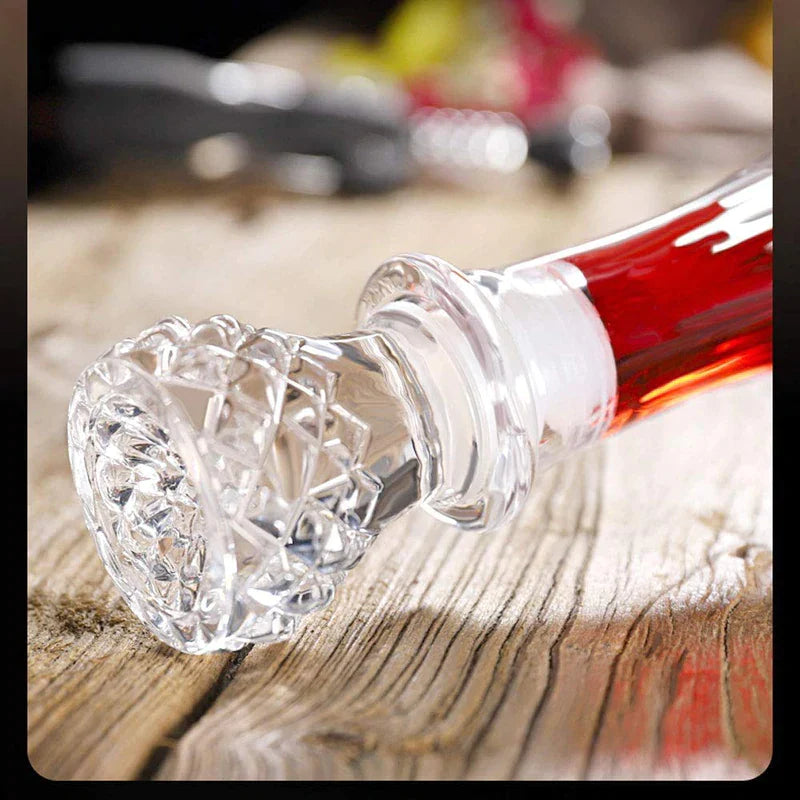 Crystal whiskey decanter stopper on rustic wooden table with red liquid inside decanter