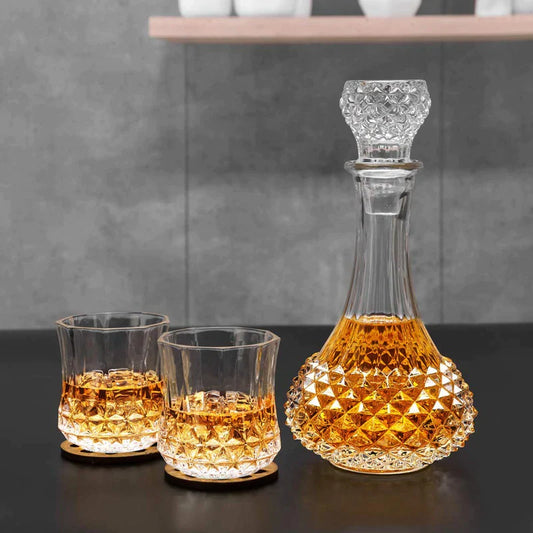 Crystal whiskey decanter and two matching glasses with amber liquid on a modern table