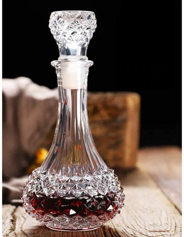 Crystal whiskey decanter with stopper on rustic wooden table, filled with liquor