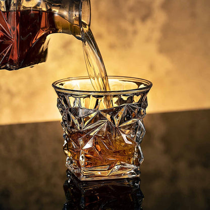 Whiskey being poured into a faceted crystal whiskey glass on a reflective bar surface