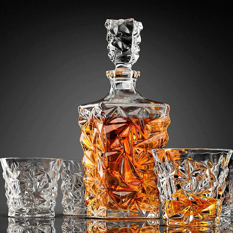 Crystal whiskey decanter and matching glasses set with geometric design, filled with whiskey