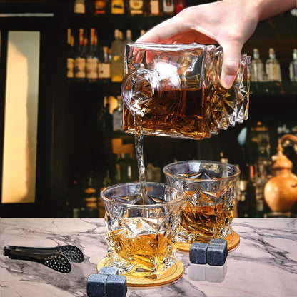Crystal whiskey decanter pouring into two whiskey glasses on marble bar with whiskey stones