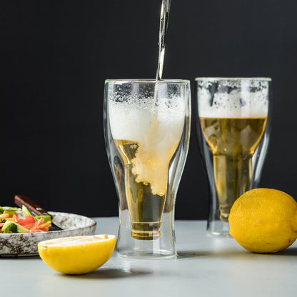 Double wall beer glasses with beer, lemons, and salad on a modern table setting