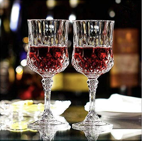 Pair of crystal wine goblets filled with red wine on a bar table, elegant barware setting