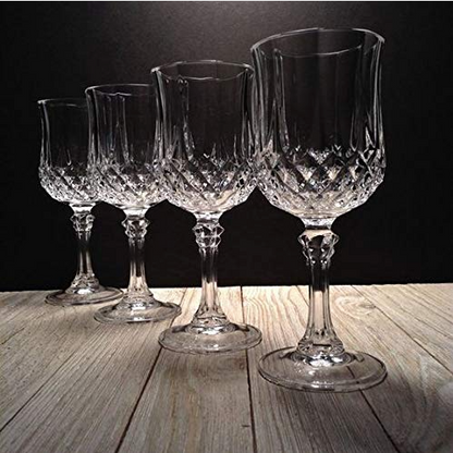 Set of four crystal wine goblets with elegant cut glass pattern on wooden surface