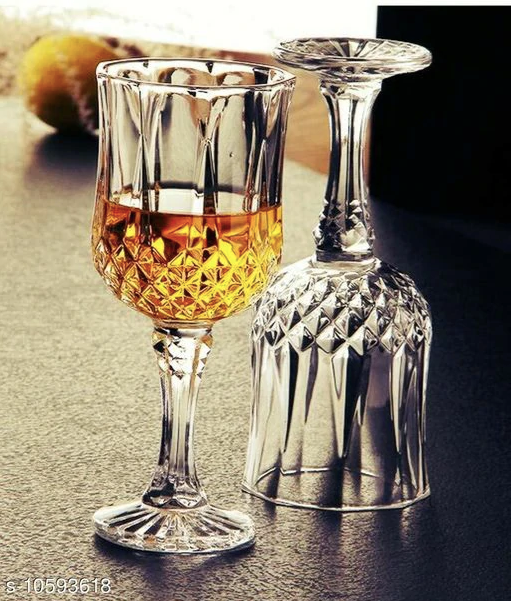 Crystal whiskey glasses with intricate cut pattern, one filled with whiskey, on bar countertop