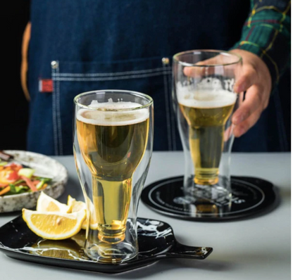 Double wall beer glasses with light beer, lemon slices on the side, modern barware setting